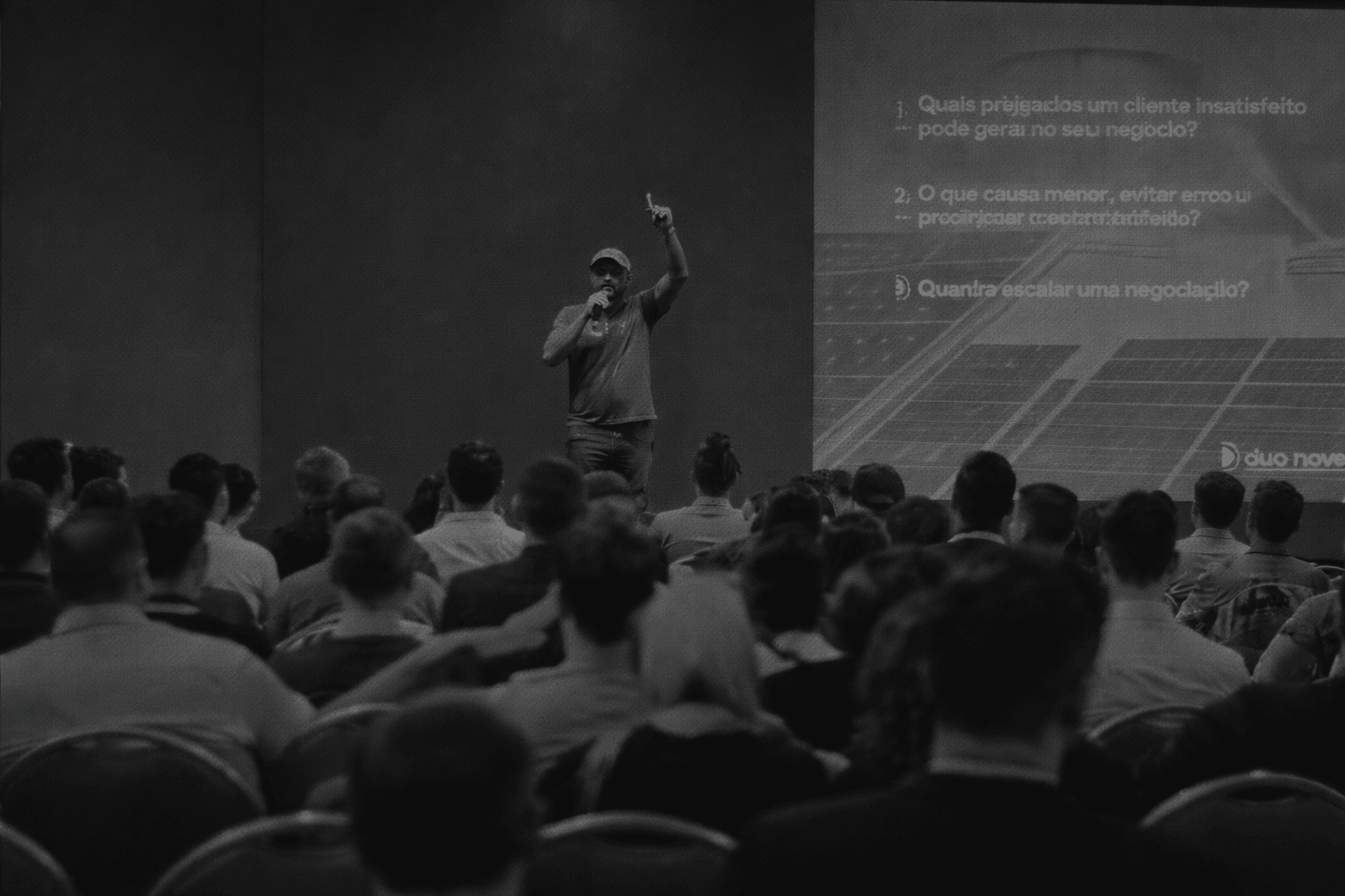 Raone palestrando no palco com plateia